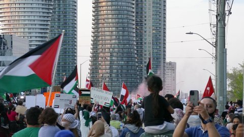 Mississauga , Canada - 05 18 2021: Demonstrators marching forward and waving Palestinian flags and recording the moments for pro-Palestinian rally in Mississauga organized by Palestinian Canadian Comm