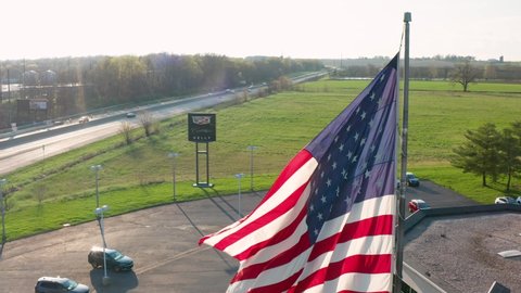 Lancaster , PA , United States - 04 11 2021: Cadillac car dealership, made in America. Aerial of American flag. US jobs and manufacturing.
