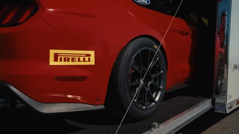 Mission , British Columbia , Canada - 09 14 2018: Red Ford Mustang GT3 Backing Out of an Enclosed Trailer at a Racetrack.