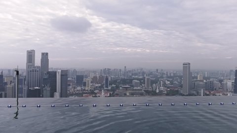 Singapore , Singapore - 02 28 2019: Cityscape View From Infinity Pool Pan Right To Tourists At Marina Bay Sands Hotel In Singapore