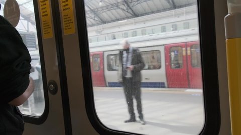 London , London , United Kingdom (UK) - 04 21 2021: London District circle line underground train doors opening to Earls court station roundel