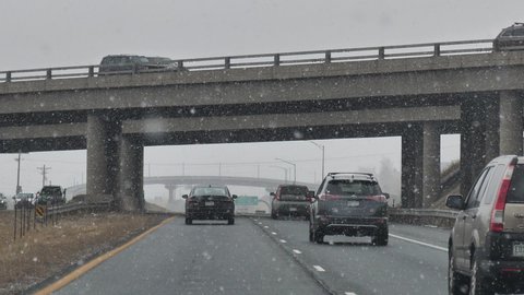 Denver , Colorado , United States - 01 25 2021: Driving on Interstate Highway Under Bridge Overpass on Snowy Winter Day Slow Motion. Car Traffic on Snowfall