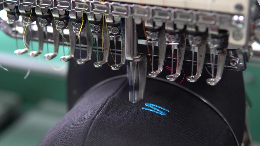 Embroidery machine in progress embroidery company logo on uniform in Textile Industry at Garment Manufacturers. Royalty-Free Stock Footage #1074576242