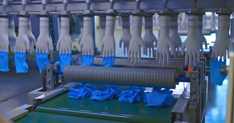Ready-made medical gloves are removed from molds, conveyor production. Modern equipment for the production of silicone medical gloves, a finished product in the workshop of the factory. 4k, ProRes