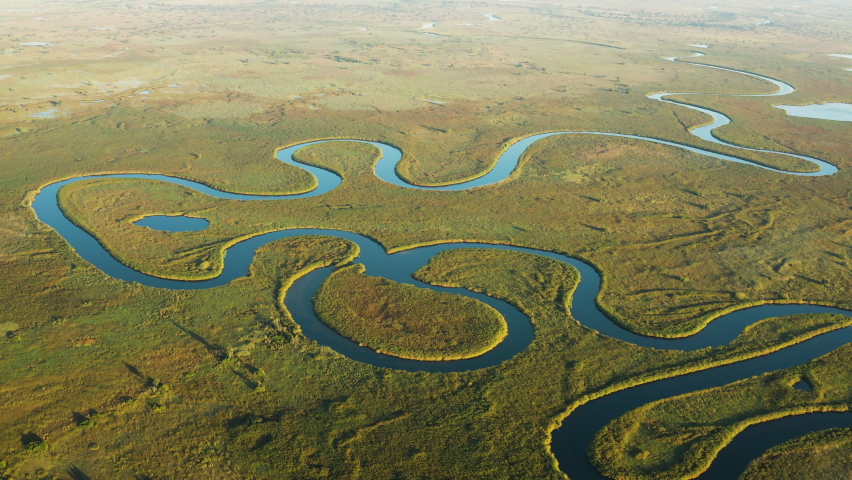 Spectacular aerial fly over view of the beautiful scenic curving patterned waterways and lagoons of the Okavango Delta Royalty-Free Stock Footage #1074580631