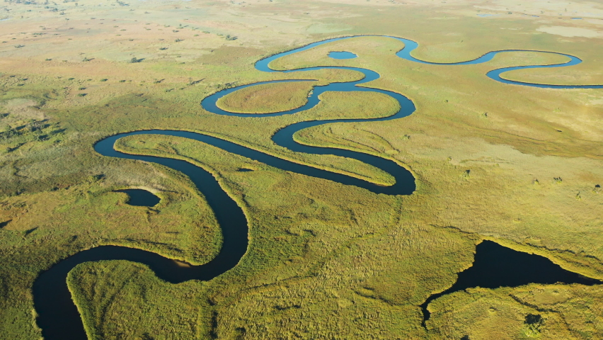 Spectacular aerial fly over view of the beautiful scenic curving patterned waterways and lagoons of the Okavango Delta | Shutterstock HD Video #1074580640