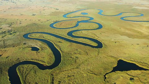 Spectacular aerial fly over view of the beautiful scenic curving patterned waterways and lagoons of the Okavango Delta