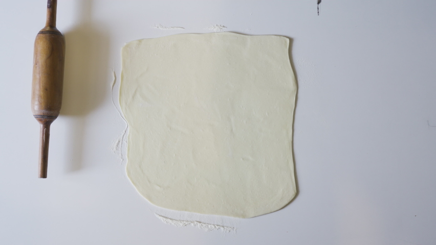 An overhead view of female hands cutting dough pieces for baking in 4K