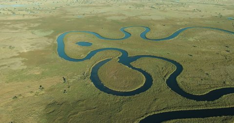 Spectacular aerial panning view of the beautiful scenic curving patterned waterways and lagoons of the Okavango Delta