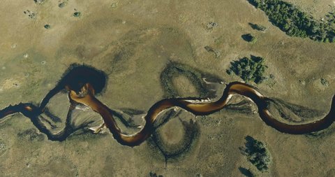 Spectacular high aerial panning view of the beautiful scenic curving patterned waterways and lagoons of the Okavango Delta