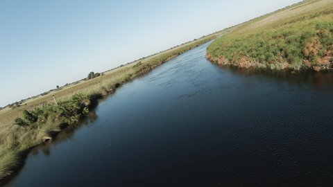 Aerial POV flying through the beautiful scenic curving patterned waterways and lagoons of the Okavango Delta