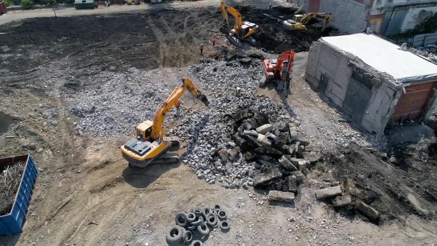 Dismantling work at the construction site. Excavators with a hydraulic hammer and workers dismantle stone debris. Site preparation for construction. Royalty-Free Stock Footage #1074584195