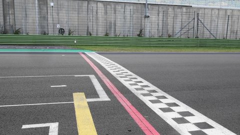 Concept of fast finish line milestone, racing car crossing asphalt checkered finish line with original engine sound