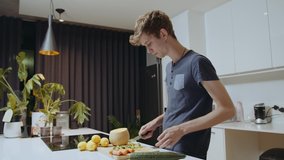 Caucasian male chopping vegetables in kitchen making healthy meal for partner