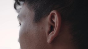 Close up mixed race male placing earphones in ears