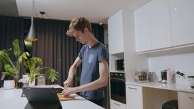 Caucasian blonde male preparing meal for male partner in kitchen