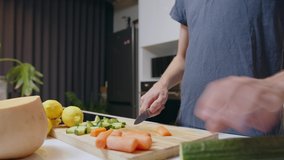 Caucasian male chopping vegetables in kitchen making healthy meal for two