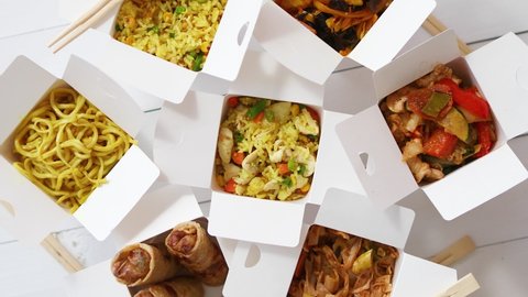 Asian take away or delivery food concept. Paper boxes placed on white wooden table