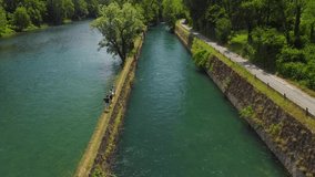 Aerial view of a mountain freshwater river surrounded by green trees. Descent along the river to the Kayak. vacation kayaking on the river. The rocky bottom of the river. drone video Trezzo sull'Adda