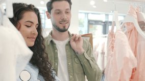 Couple shopping for clothes looking at prices and shaking head feeling unhappy in store. Financial problems and expensive fashionable garments concept. - Powered by Shutterstock - Get 15% off with code: PIKWIZARD15