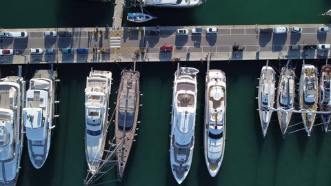 Luxury Yachts And Sailboats Docked At The Marina With Parked Cars In Palma De Mallorca, Spain. aerial top-down