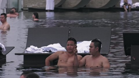 Singapore , Singapore - 02 28 2019: Tourists Relaxing In Infinity Pool At Marina Bay Sands Hotel In Singapore. Locked Off 