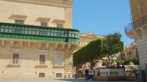 Valletta , Malta - 06 06 2021: Grandmaster's Palace facade in St Georges Square. Day view of the Governors Palace with traditional Maltese architecture and tourists at the square