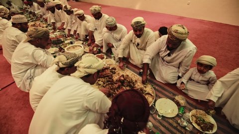 Muscat , Oman , Oman - 05 06 2018: Omani Men eating in traditional Oman Banquet buffet dinner 