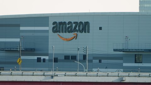 Tokyo , Japan - 01 25 2021: Amazon Warehouse in Futakotamagawa with Traffics Passing By in the Foreground