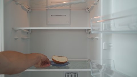 Hungry Man Opens the Empty Refrigerator and Takes the Leftover Bread. Poverty and Economic Crisis Concept. No Money or Food. Shooting from the First Person. POV