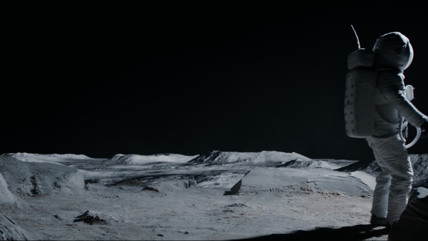 Male astronaut performing moonwalk dance move on a Moon surface. Shot with 2x anamorphic lens Royalty-Free Stock Footage #1074629111