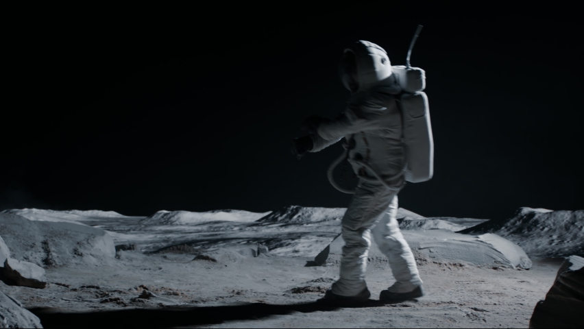 Male astronaut performing moonwalk dance move on a Moon surface. Shot with 2x anamorphic lens | Shutterstock HD Video #1074629111