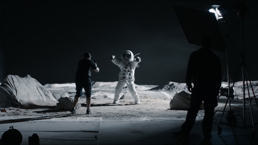 WIDE Behind the scenes, cinematographer shooting viral video for social account on a large Moon landing set. Virtual production with LED screens. Shot with 2x anamorphic lens Royalty-Free Stock Footage #1074629120