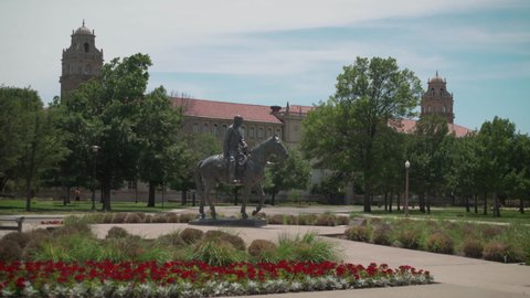 Lubbock, Texas - June 5, 2021: Texas Tech University Will Rogers and Soapsuds statue with campus buildings