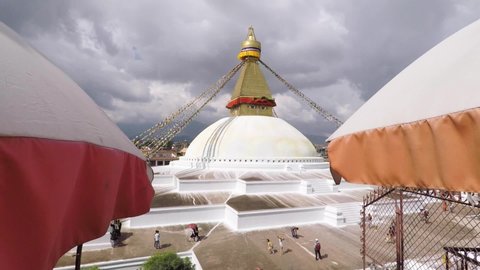 Buddhist Bodnath (Boudha) Stupa, a famous religious monument in Kathmandu, Nepal decorated with colorful prayer flags flying in the wind. View from above.