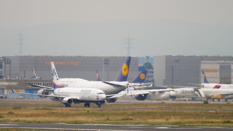 FRANKFURT AM MAIN, GERMANY - JULY 19, 2017: Frankfurt international Airport busy day with lots of plane on tarmac. Lufthansa Airlines Airbus A321 plane arrive and Lufthansa boeinf 747 take-off