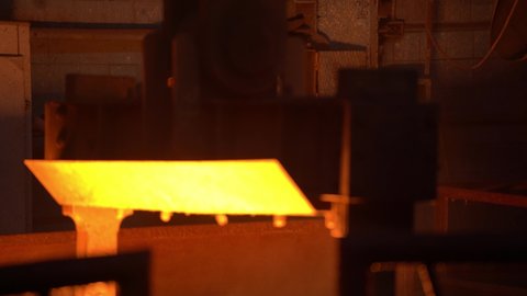 A bowl of molten metal rises up in the smelter. Concept: heat-resistant crucible, mechanical engineering and heavy industry.