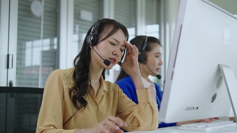 Call center asia woman using computer in office, thinking hard, wondering, stressed, worried about customer problems.telemarketing. Customer support representatives