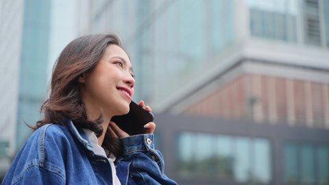 lovely charming asian girl talking on the phone in the urban city slow motion young business woman listening phone call using cell phone