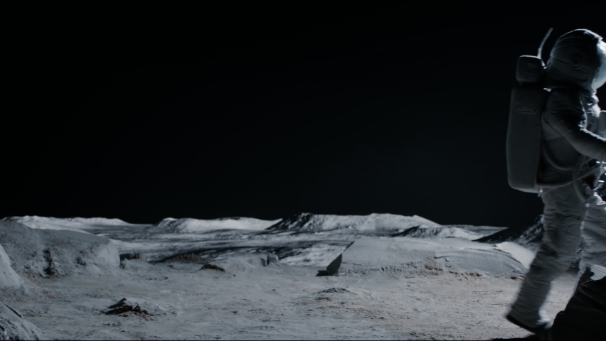 Male astronaut performing moonwalk dance move on a Moon surface. Shot with 2x anamorphic lens Royalty-Free Stock Footage #1074657335