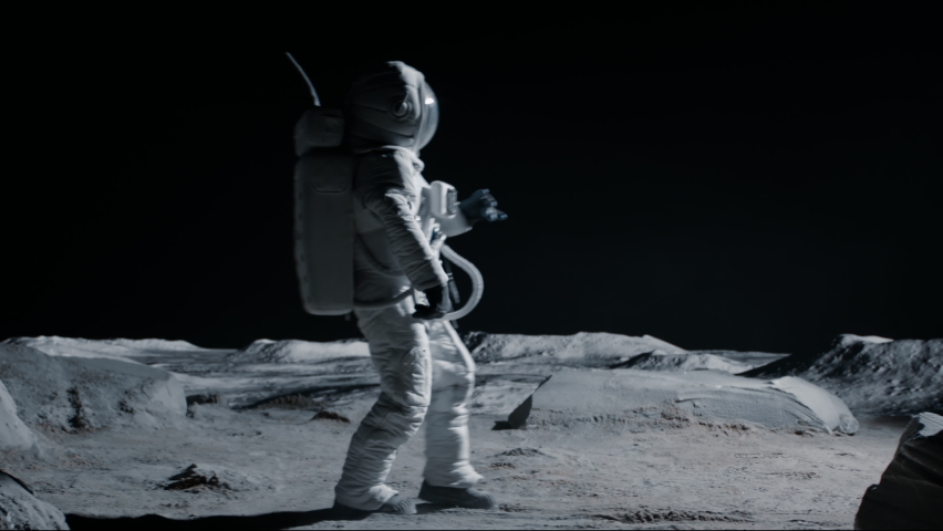Male astronaut performing moonwalk dance move on a Moon surface. Shot with 2x anamorphic lens | Shutterstock HD Video #1074657335