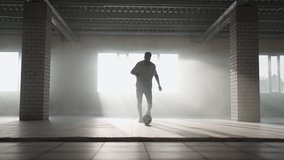 Football freestyle slow motion. Young black man practices with soccer ball in underground parking. Coaching a young African American aspiring to and working on the dream of becoming a football player - Powered by Shutterstock - Get 15% off with code: PIKWIZARD15