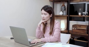 Beautiful woman works at home with a laptop computer, Asian businesswoman meeting online via video at home.