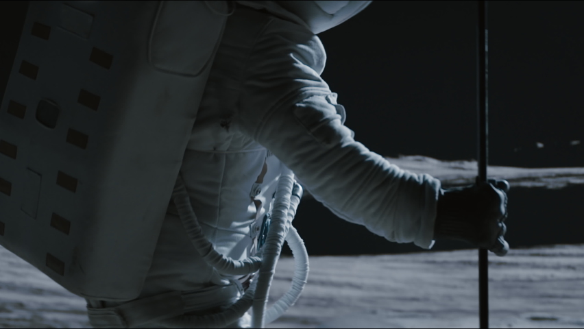 Portrait of Asian lunar astronaut placing a flag pole on the Moon surface. Easy to track and add your flag. Shot with 2x anamorphic lens | Shutterstock HD Video #1074664766