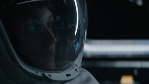 Portrait of Caucasian female astronaut inside spaceship cockpit. Sci-fi space exploration concept. Moon mission. Shot with 2x Anamorphic lens