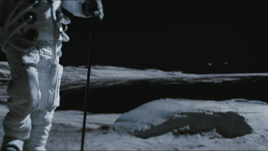 Portrait of Asian lunar astronaut placing a flag pole on the Moon surface. Easy to track and add your flag. Shot with 2x anamorphic lens Royalty-Free Stock Footage #1074671846