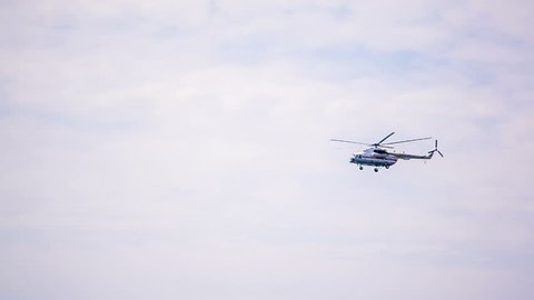This is a video footage of a helicopter flying up in the cloudy sky. It's moving from the right side to the left.