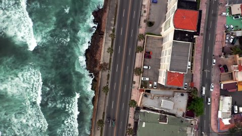 Waves crashing on reef along Malecon in Santo Domingo. Aerial top-down forward