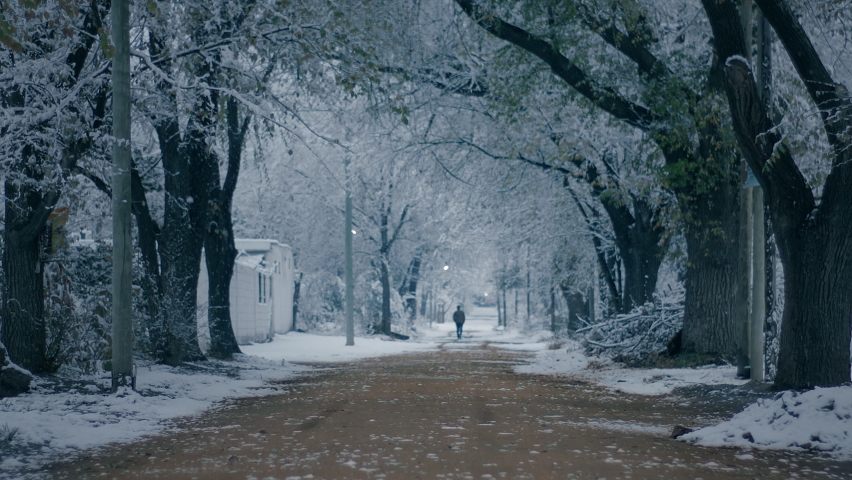 Man walking on dirt road, in winter season. Snow fall. Slow Motion. Winter in Cordoba, Argentina 2021