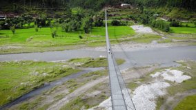 Children are running on the suspension bridge in Nepal, aerial drone video